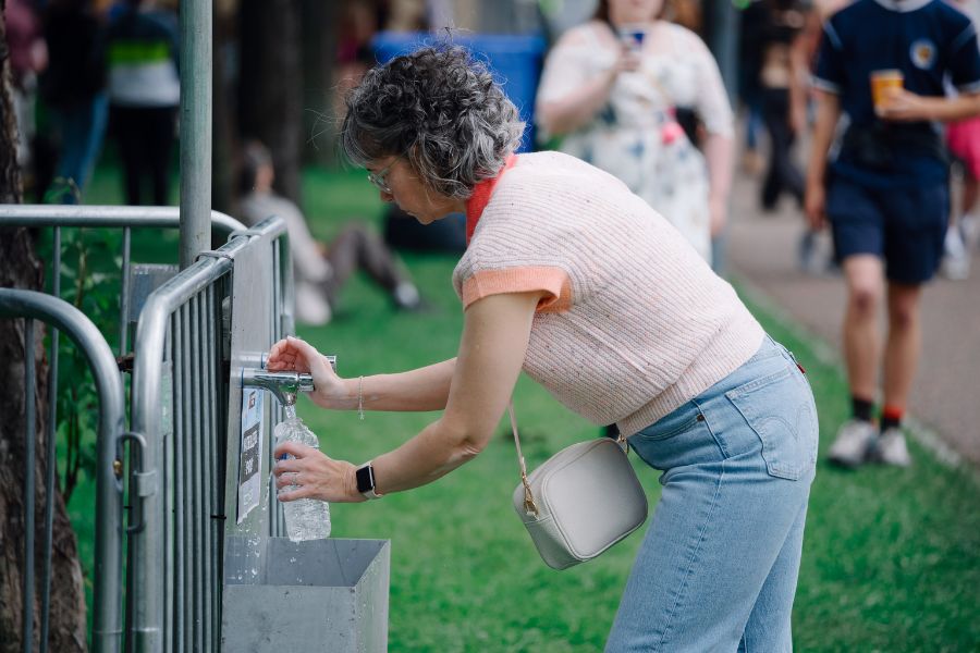 Woman filling up waterbottle.
