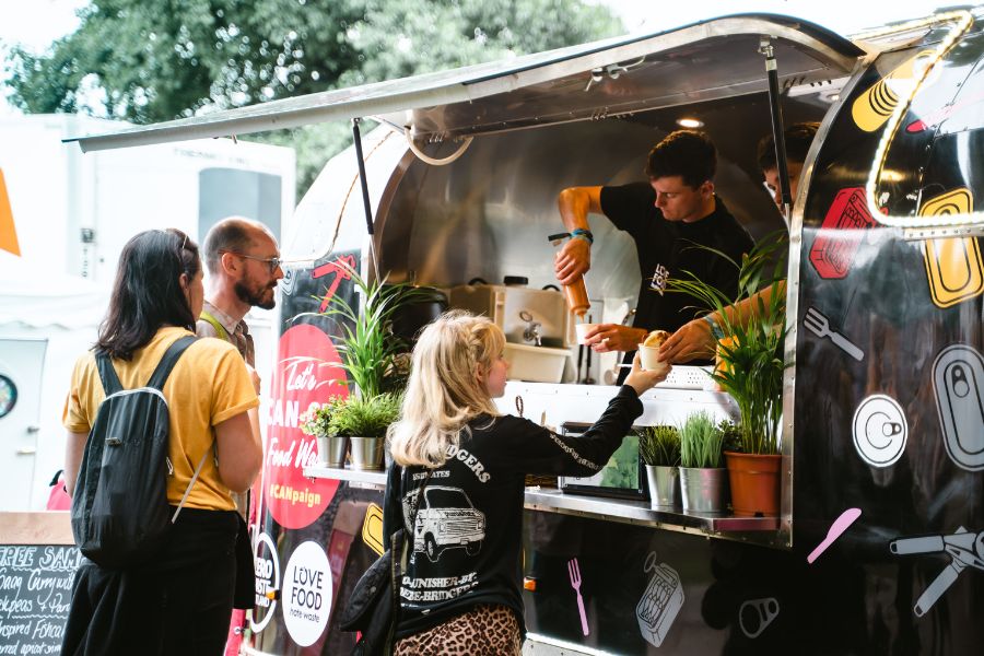 Woman collecting food from a food truck at a festival.